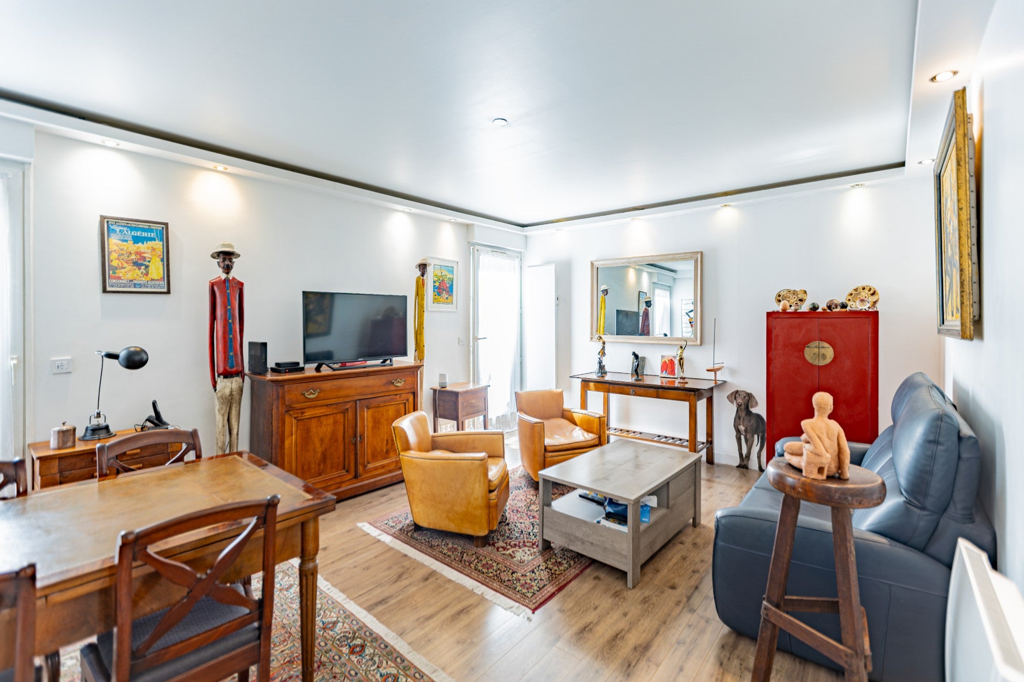 Séjour avec fauteuils club en cuir, table de repas et cabinet laqué rouge, photographié par KEY STUDIO