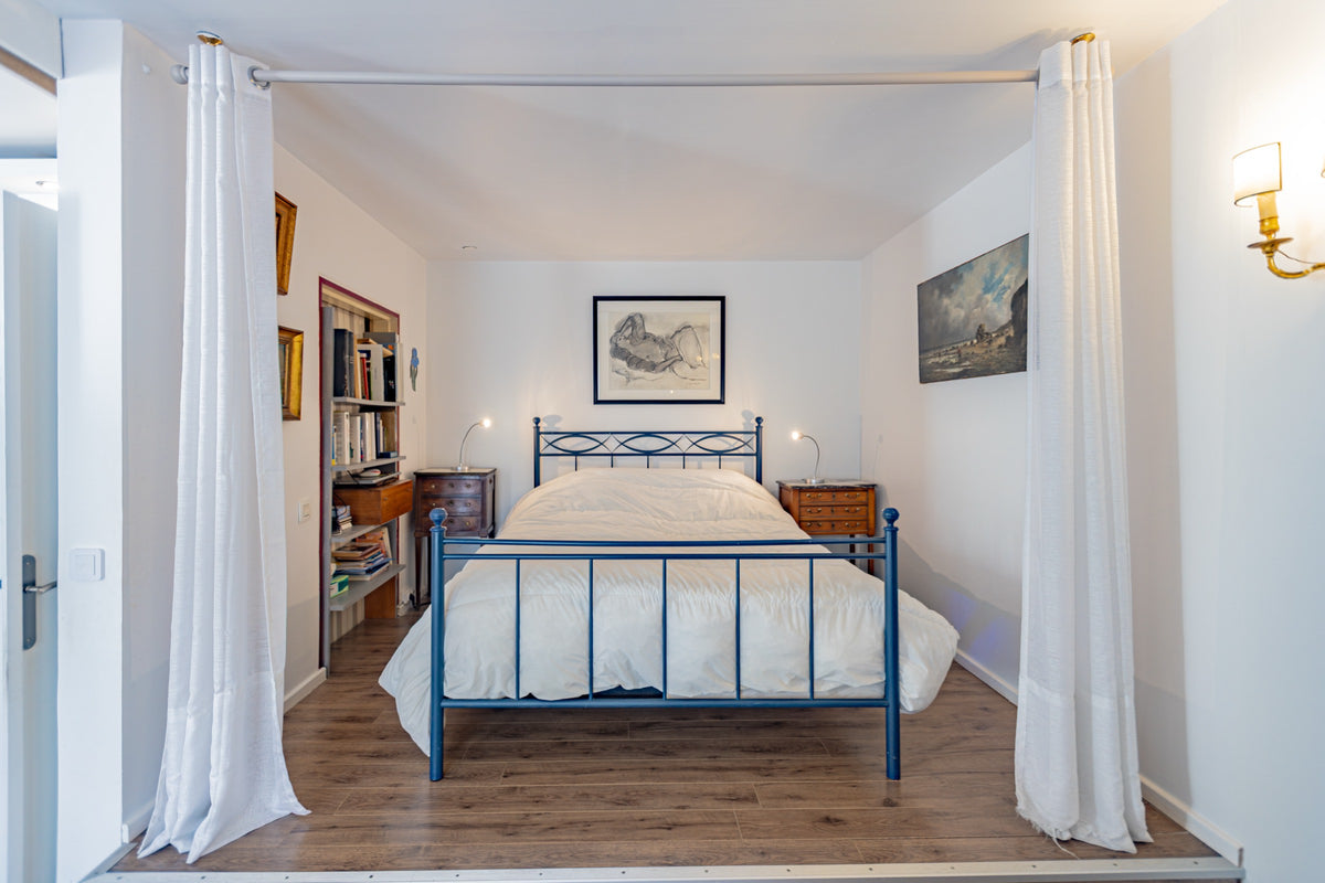 Chambre sur estrade, lit en fer et rideaux blancs, appartement à Asnières.